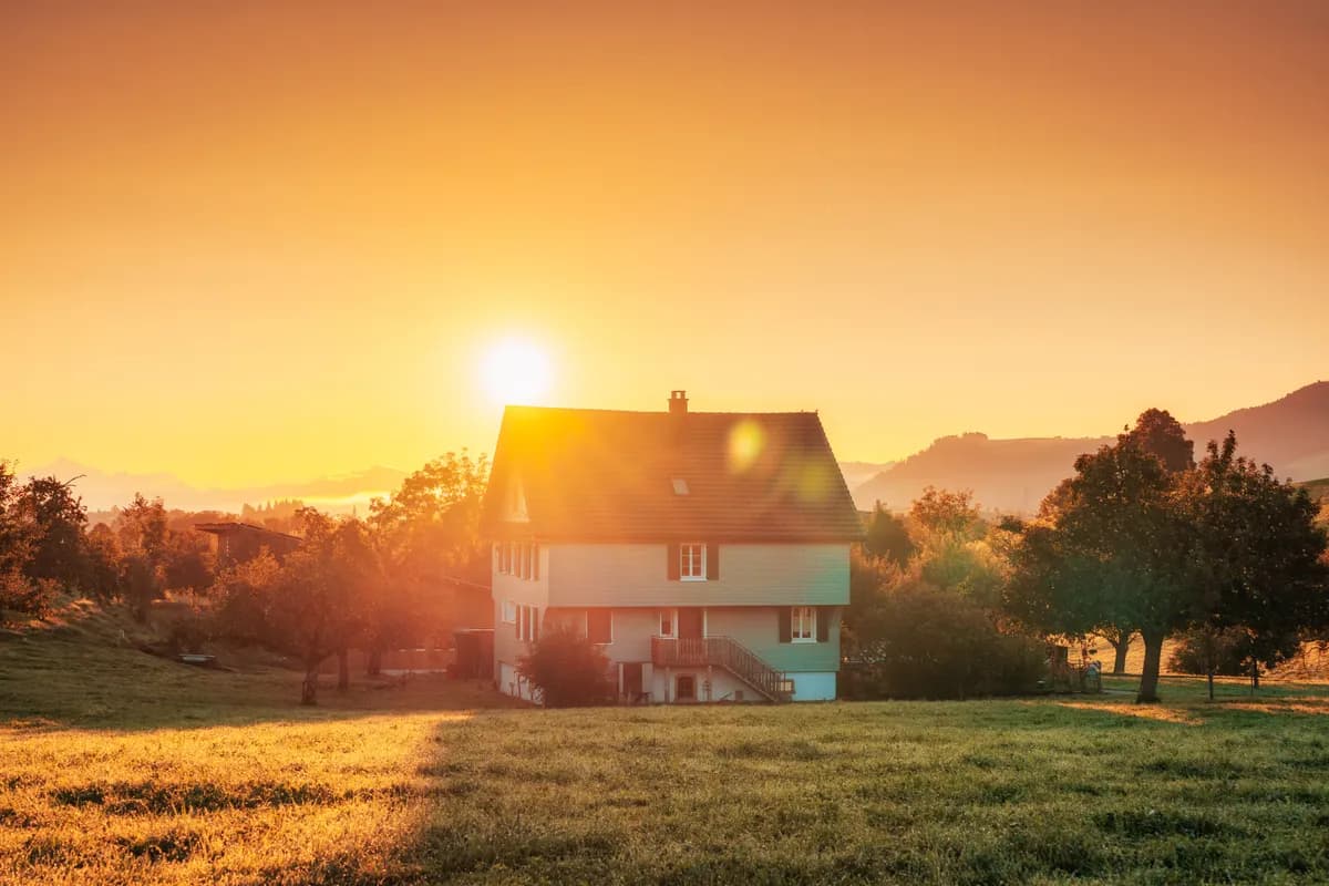 Sunrise behind a suburban home — the recovery arc after a credit event